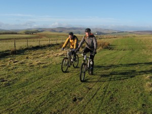 Ken and Steve riding acorss Pen y Gwely with the Berwyns in the distance. 