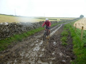 Alex on the muddy in the wet Wormhill descent. 